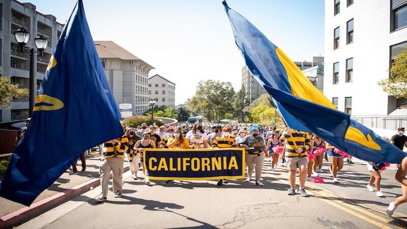 UC Berkeley students holding and walking homecoming banner.