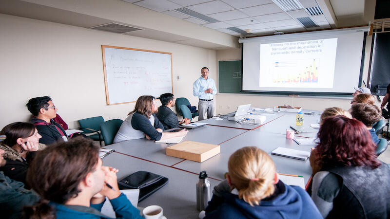 Teaching and leading in a conference room around tables to symbolize a work environment. 