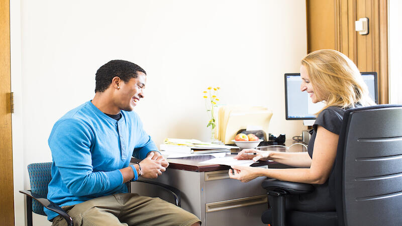 Two people engaging in a professional setting, having a professional conversation. 